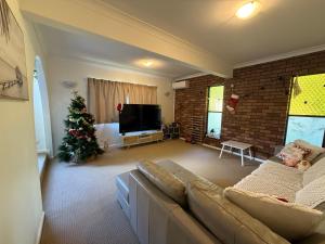 een woonkamer met een kerstboom en een bank bij 4BR big family house with huge pool in Brisbane