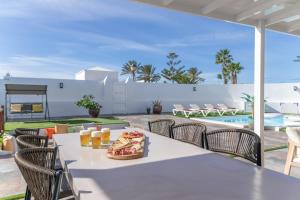 un tavolo con pizza e bevande su un patio di The Suite Villa a Playa Blanca