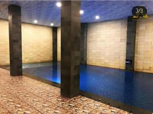 ein Schwimmbecken in einem Gebäude mit zwei Säulen in der Unterkunft pyramid suites Hotel in Banjarmasin