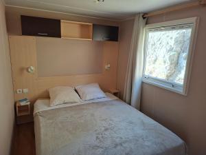 ein kleines Schlafzimmer mit einem Bett und einem Fenster in der Unterkunft Mira Monti Location in Belvédère