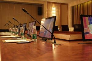 ein langer Tisch mit mehreren Computern und einem Mikrofon in der Unterkunft Suqian Hengli International Hotel in Suqian + 113 Fotos