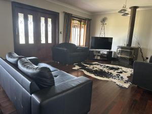 Loudawn Homestead في كورا: غرفة معيشة مع أريكة وتلفزيون