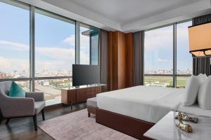 a hotel room with a bed and a large window at Crowne Plaza Phnom Penh by IHG in Phnom Penh +31 photos