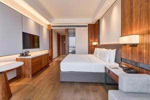 a bedroom with a large white bed and a sink at Crowne Plaza Phnom Penh by IHG in Phnom Penh
