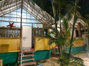 a small house with a yellow and green facade at Cozy Nook Goa Palolem in Palolem