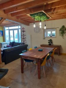 a living room with a wooden table and chairs at La Longère des Oies in Saint-Thibault