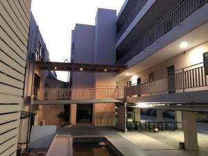 Sattahip 9 Boutique Hotel في ساتاهيب: عمارة سكنية مع شرفة ومسبح