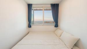 Un dormitorio con una ventana con vista al mar. en yeongdeok chaeumneul poolvilla, en Yŏngdŏk