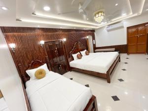 a bedroom with two beds in a room with at Shree Jyotirlinga Heritage INN in Kolhapur