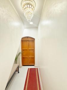 a hallway with a red carpet and a chandelier at Shree Jyotirlinga Heritage INN in Kolhapur