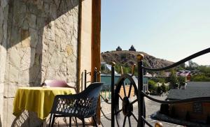 una mesa y sillas en un balcón con una montaña en Чичхани Chichxani Kambuz, en Aghk'ilisa