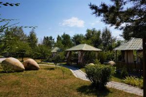 Un jardín con algunas rocas grandes y algunos edificios. en Чичхани Chichxani Kambuz, en Aghk'ilisa