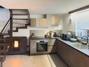 a kitchen with a staircase and a sink and a stove at Little Wild House in Saint Vincent