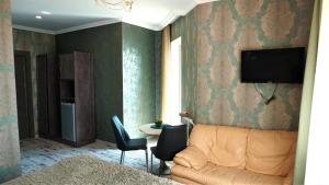 Una sala de estar con un sofá y un televisor en una pared. en Чичхани Chichxani Kambuz, en Aghk'ilisa