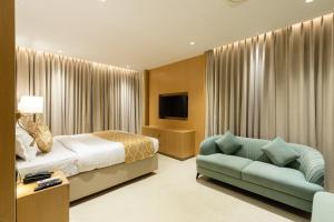 a hotel room with a bed and a couch at JALSA HOTEL & BANQUETS,Indore in Indore