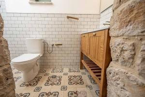 a bathroom with a toilet and a tile floor at Moses Luxury apartments 36 a in Safed