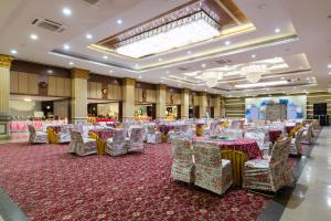 a banquet hall with tables and chairs on a red rug at JALSA HOTEL & BANQUETS,Indore in Indore