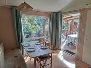 ein Esszimmer mit einem Tisch und einem großen Fenster in der Unterkunft Mira Monti Location in Belvédère