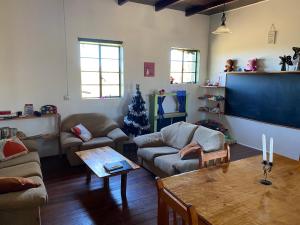 een woonkamer met twee banken, een tafel en een schoolbord bij Infinity farm in Riversdale