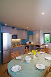 una cucina con tavolo, piatti e fiori di Confort détente près de la plage - Maison avec jardin et parking privé - Veules-les-Roses a Veules-les-Roses