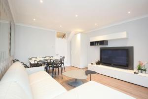 a living room with a couch and a tv at Sach's 2 Bedrooms Apartment - No lift in London
