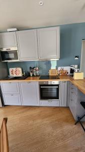 una cucina con mobili bianchi e un piano di lavoro di Confort détente près de la plage - Maison avec jardin et parking privé - Veules-les-Roses a Veules-les-Roses Altre 17 foto