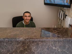 La Majestic Guest Lodge في سنتوريون: رجل يجلس على كرسي عند طاولة ذات سطح منضدي