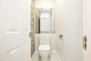 a white bathroom with a toilet and a window at Sach's 2 Bedrooms Apartment - No lift in London