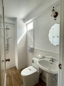 a white bathroom with a toilet and a sink at Chermonné House เฌอมอญ  +7 photos
