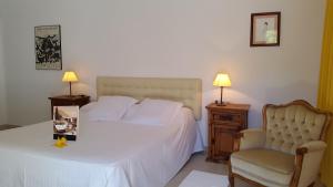a bedroom with a white bed and a chair at Hotel Rural Can Maries in Puerto de San Miguel