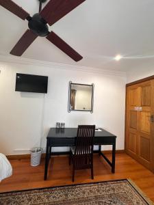 a room with a black desk and a ceiling fan at Tsheryl's Residence in Centurion