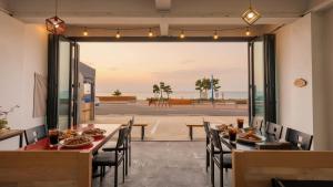 ヤンヤンにあるYangyang Verit Pensionの海の景色を望むテーブルと椅子付きのレストラン