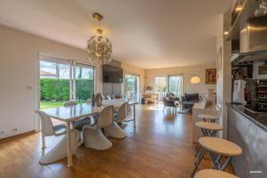 eine Küche und ein Wohnzimmer mit Tisch und Stühlen in der Unterkunft La maison du bonheur in Pin-Balma