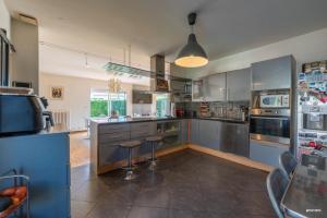 eine große Küche mit Geräten und Arbeitsplatten aus Edelstahl in der Unterkunft La maison du bonheur in Pin-Balma