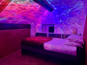 een kamer met een bed met roze verlichting bij Old Post Office By The Sea in Allonby