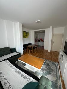 een woonkamer met een bank en een tafel bij Apartman Ranija in Rožaje