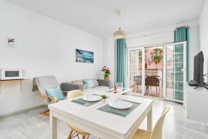 een woonkamer met een tafel en een bank bij Apto 3 Almoraide Suites in Nerja
