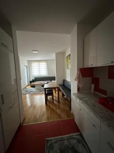 een keuken en woonkamer met een tafel en een bank bij Apartman Ranija in Rožaje