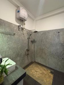 een badkamer met een douche en een wastafel in de kamer bij John's Homestay in Talpe