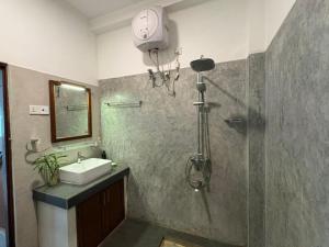 a bathroom with a shower with a sink and a shower at John's Homestay in Talpe