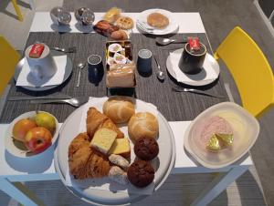 a table with plates of breakfast foods on it at B&B Giolì in Milan