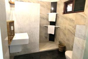 une salle de bain avec un lavabo et un miroir et des toilettes dans l'établissement Papaya Hikkaduwa, à Hikkaduwa