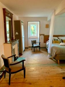 ein Schlafzimmer mit einem Bett, einem Stuhl und einem Fenster in der Unterkunft La FortBelle in Beaufort