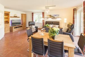 a living room with a wooden table and chairs at Haus Eichenwald in Glowe
