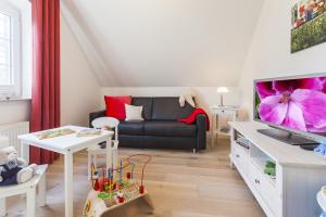 a living room with a couch and a tv at Haus Eichenwald in Glowe