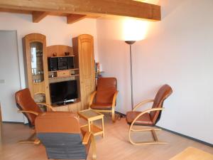 Spacious Apartment in Boddin with Garden في Boddin: غرفة معيشة مع كراسي وتلفزيون بشاشة مسطحة