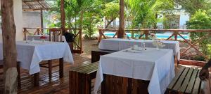 two tables with white table cloths on them in a restaurant at TheChef NungwiBungalow in Kidoti