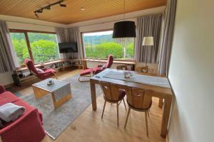 a living room with a table and a red couch at Ferienhaus Rothaarblick in Schmallenberg