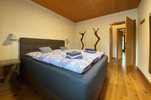 a bedroom with a large bed with blue pillows at Ferienhaus Rothaarblick in Schmallenberg