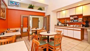 een keuken en eetkamer met tafels en stoelen bij Magnuson Hotel Manitou Springs in Manitou Springs